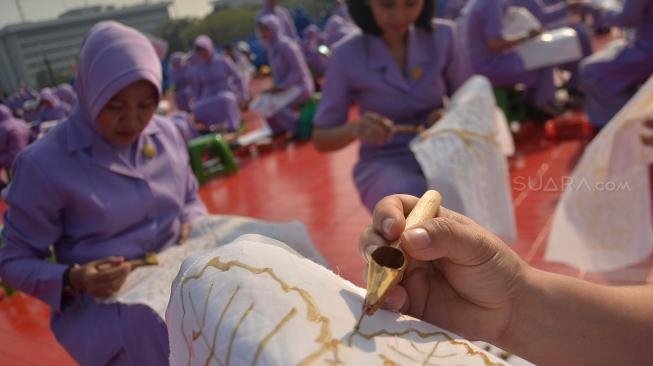 Ribuan anggota Dharma Pertiwi TNI mengikuti pemecahan rekor MURI membatik dengan canting di Mabes TNI Cilangkap, Jakarta, Selasa (2/10). (Suara.com/Muhaimin A Untung)