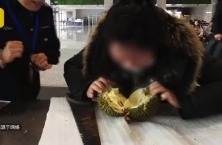 Penumpang wanita makan durian. (YouTube/Netizen Watch)