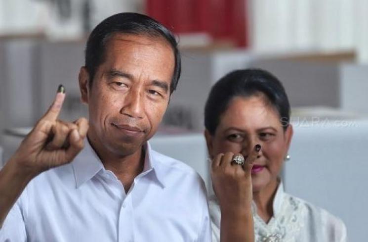 Calon Presiden nomor urut 01 Joko Widodo menggunakan hak suaranya bersama sang istri, Iriana Joko Widodo, di TPS, Jakarta Pusat, Rabu (17/4/2019). (Suara.com/Muhaimin A Untung)
