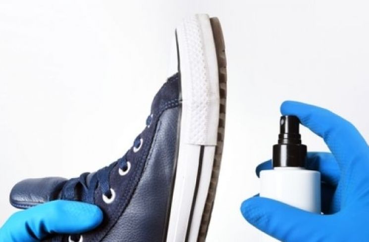 Membersihkan sepatu dengan cairan disinfektan (Shutterstock)
