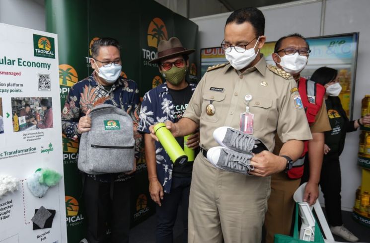 Gubernur DKI Jakarta, Anies Baswedan mengamati tas sekolah serta sepatu dari bahan daur ulang sampah. (Istimewa)
