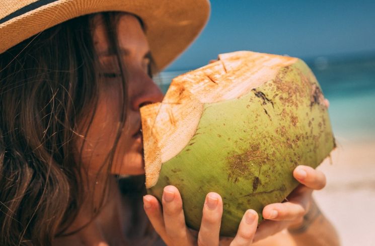 Ilustrasi perempuan minum air kelapa muda (Pexels/Mikhail Nilov)