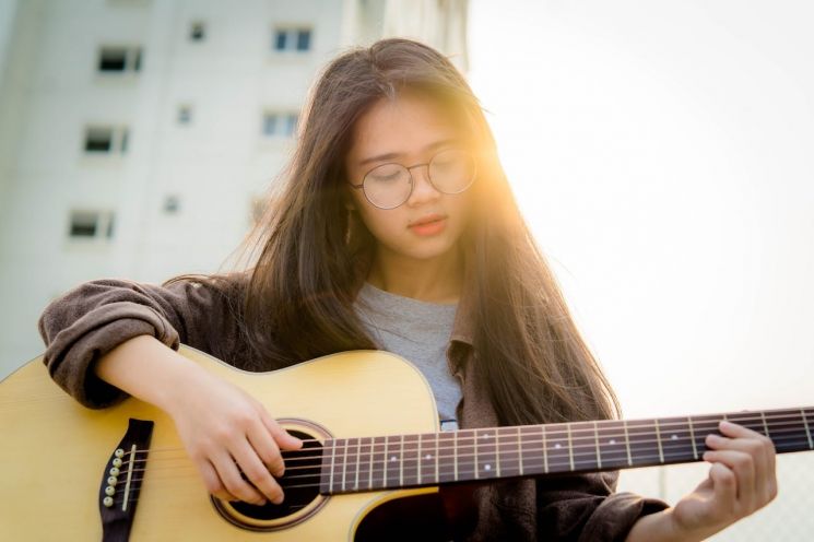 Ilustrasi perempuan bermain gitar (Pexels/Quoc Bao)