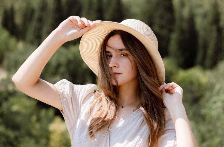 Ilustrasi perempuan menggunakan topi di bawah terik matahari (Pexels/iilushk0)