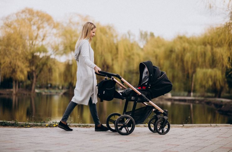 Ilustrasi ibu menggunakan stroller untuk mengajak bayi jalan-jalan di taman. (Freepik/senivpetro)