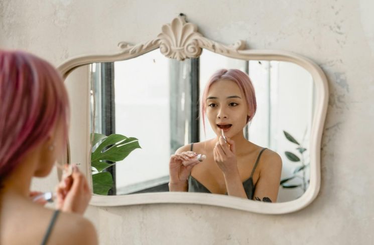 Ilustrasi perempuan merawat kecantikan bibir dengan memakai lip serum (Pexels/Tima Miroshnichenko)