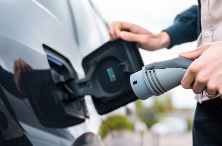 Ilustrasi pengisian daya pada mobil listrik sebagai transisi energi terbarukan (Freepik/frimufilms)